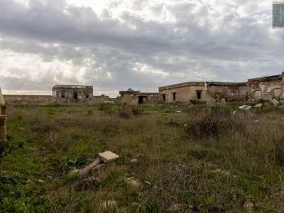 Lato terra continua per� la desolazione con una stradina in salita che costeggia basse palazzine decadenti...